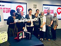 Mayor Bowser with a group of people, holding a #SaferStrongerDC sign